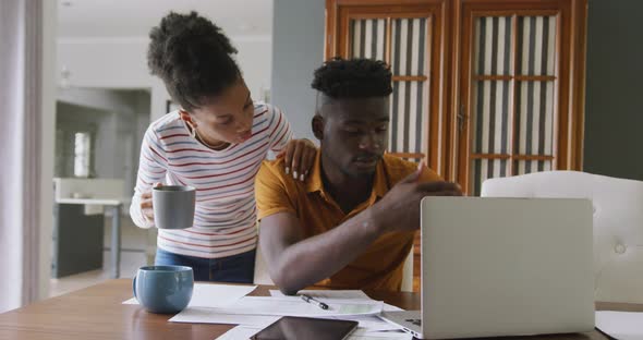 Video of serious african american couple using laptop, paying bills