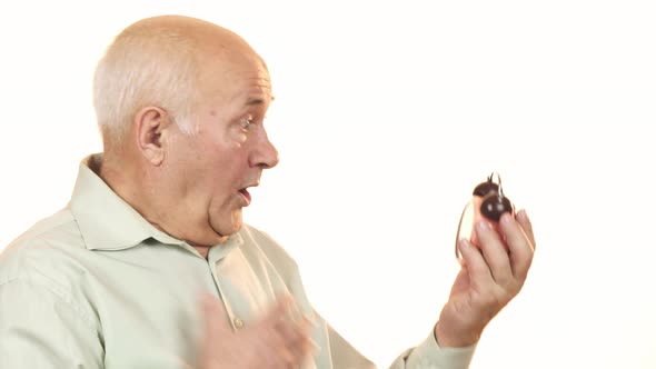 Senior Man Looking Shocked Checking Time on Alarm Clock