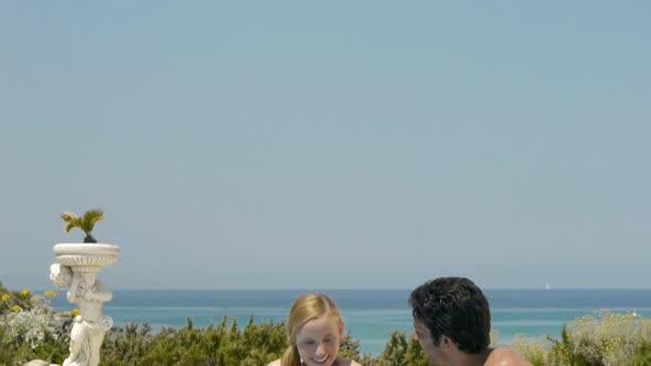 Young couple sitting at poolside