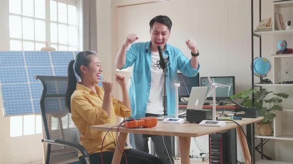 Asian Man And Woman Being Happy Succeed Testing The Wind Turbine While Working With Laptop