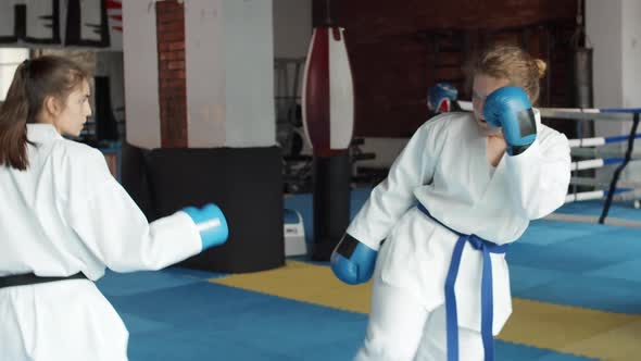 Two Young Sportswomen Exercising on Ring