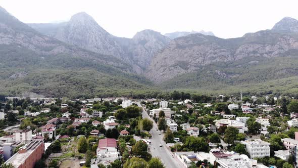 Aerial View of the Town at the Foot of the Treecovered Mountains and the Central Road with a Cluster