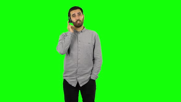 Brunette Guy with Headset Helping with Customer Service. Green Screen