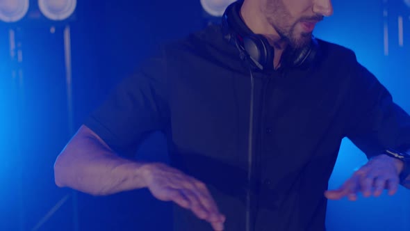 Live DJ Performance of Energetic Bald Man with Headphones Dancing on Party Concert Musician Stage