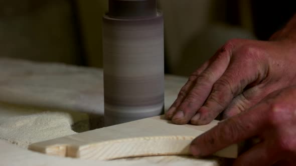 Hands of Carpenter Working with Wooden Plank