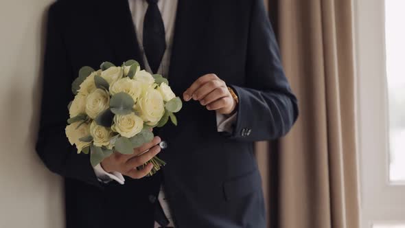 Groom with Wedding Bouquet in His Hands at Home Preparing to Go to Bride Closeup Slow Motion