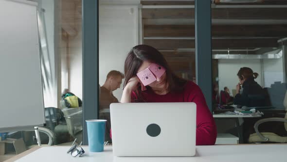 Funny Procrastination Businesswoman Napping at Workplace Covering Eyes with Sticky Notes
