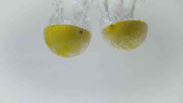 Sectioned honeymelon dropped into water, Ultra Slow Motion alt