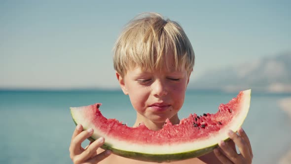 Boy Eating Watermelon on the Beach Summertime