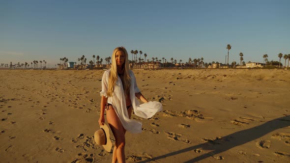 Attractive Blond Woman Walking on the Beach