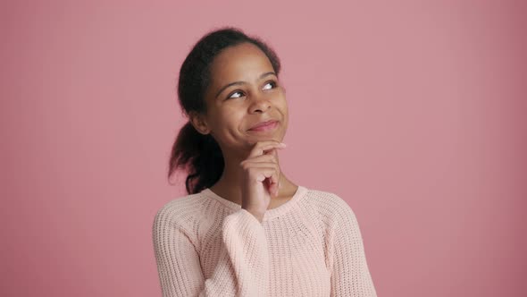 Pensive African little girl looking to the top sides and agree with something