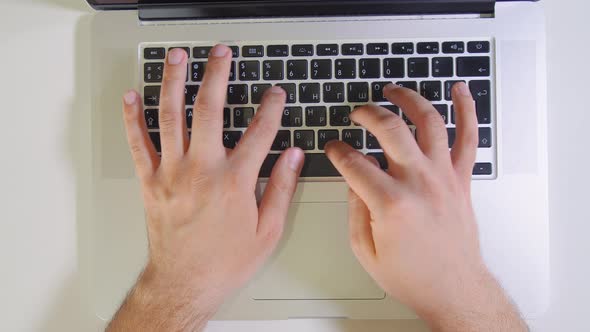 Hand of Man Working at Laptop Computer Typing on Keyboard