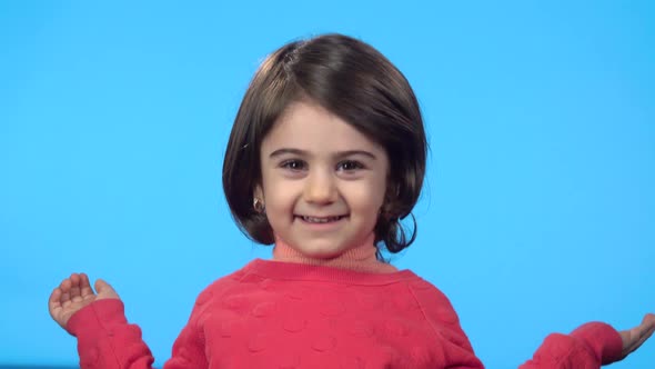 Little Brunette Girl Looking at Camera, Smiling and Playing Hide-and-seek.