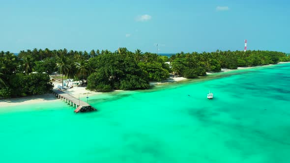 Natural flying tourism shot of a sunshine white sandy paradise beach and blue sea background 