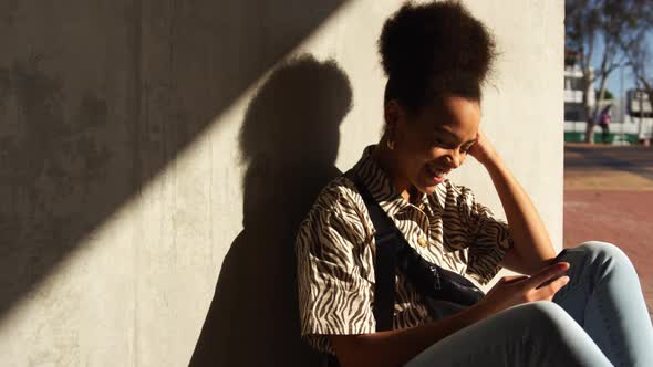 Mixed race woman on smartphone under bridge