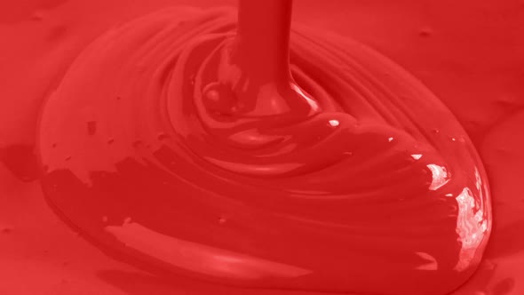 Red Paint Is Poured Closeup
