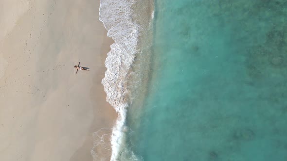 Lying woman on sandy beach enjoying beautiful weather and tropical landscape on Gili Meno Island.Aer