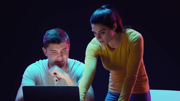 Man and woman working on laptop