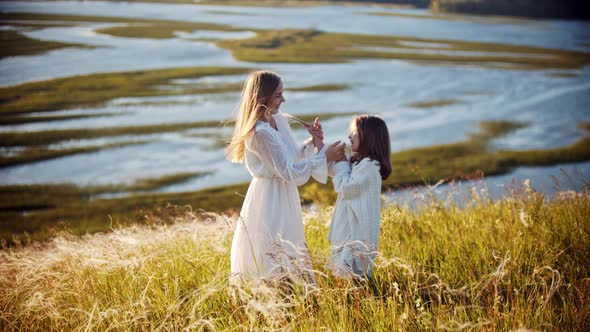 Happy Family Concept - Little Girl and Her Mother Hugging on the Wheat Field