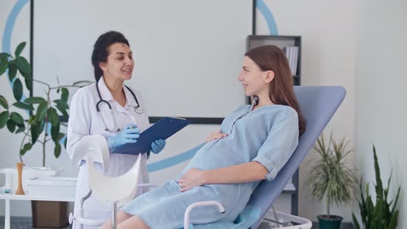 Happy Pregnant Woman Visit Gynecologist Doctor at the Medical Clinic.