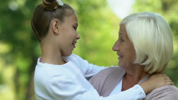 Little Beautiful Girl Laughing and Fooling Around With Her Old Grandmother