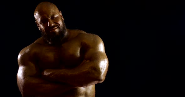 a Bearded Bald Brutal Male Bodybuilder with a Naked Inflated Torso, He Is in the Studio on a Black