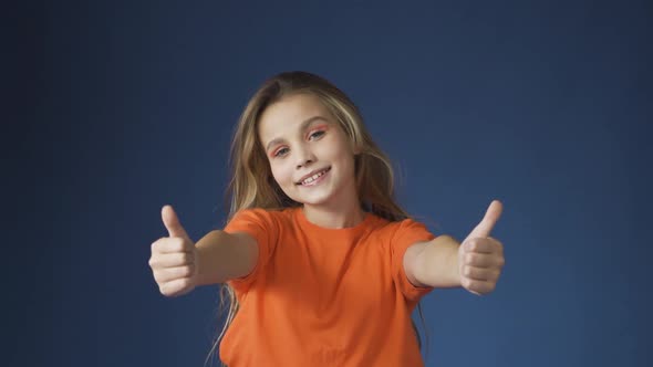 A Young Teenage Girl Shows a Thumbs Up Gesture