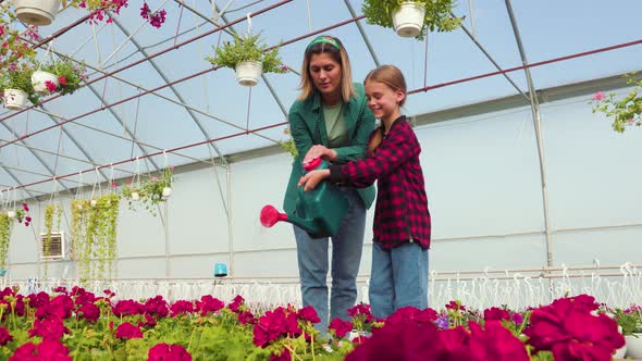 Mother Florist and Her Little Daughter Watering Plants and Flowers