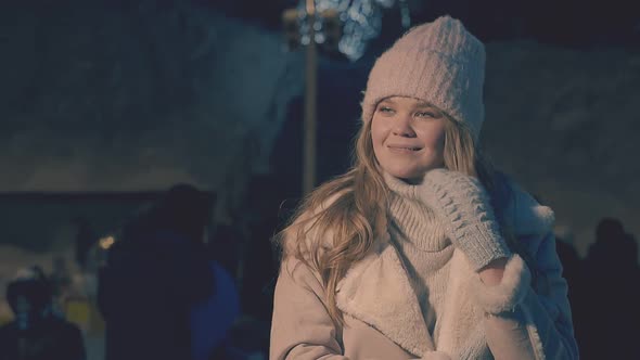 Happy Woman Fixes Long Hair By Hand in Mitten at Winter Fair