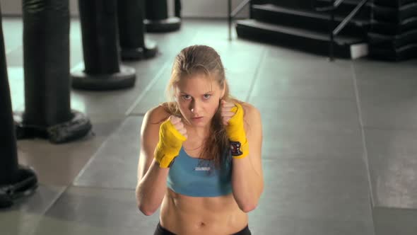 Woman doing Muay Thai kickboxing training at the gym.