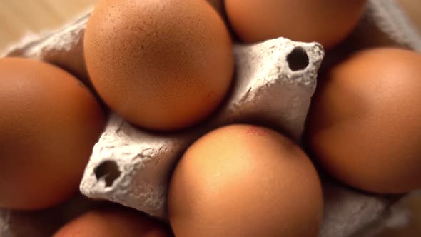 close up of brown eggs in egg carton on rustic background