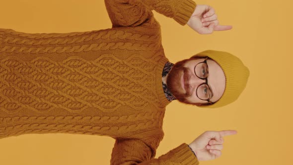 Vertical Video European Hipster Keeps His Hands Up Points Above Him Portrait Isolated Copy Space