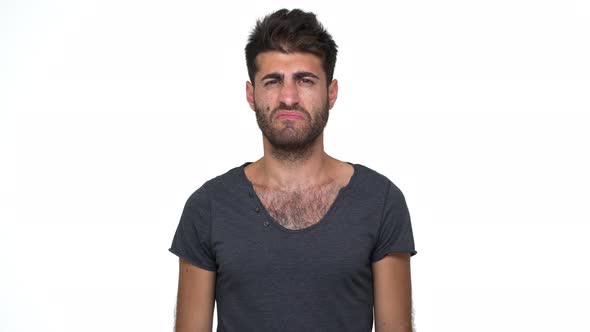 Skinny Young Man Wearing Grey Tshirt Pinching Nose with Disgust on His Face Due to Bad Smell