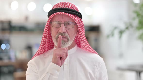 Senior Old Arab Businessman Putting Finger on Lips Quiet