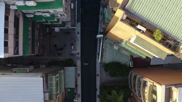 A 90 degree Drone shot of an unrecognizable man walking in the street in Taipei by sunset