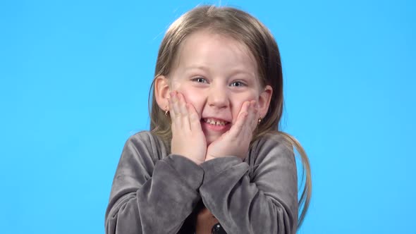 Blonde Child Is Smiling, Looking Overjoyed and Nodding Her Head.