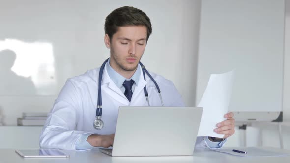 Young Doctor Working On Laptop and Medical Documents