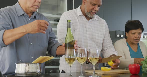 Happy senior diverse people cooking in kitchen at retirement home