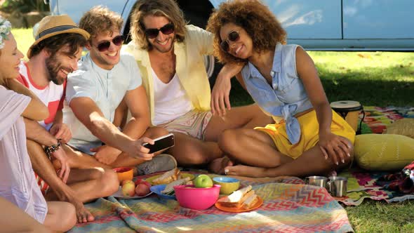 Group of hipster friends watching something on smartphone