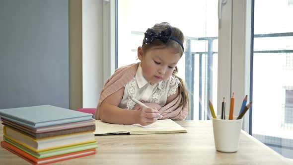 Little Elementary Schoolgirl Doing Homework. Cute Child Learns on His Own. Back To School.