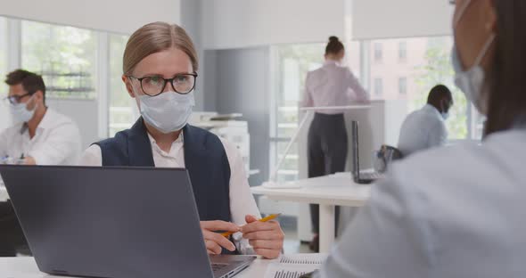 View Over Shoulder of African Female Client in Safety Mask at Meeting with Bank Manager