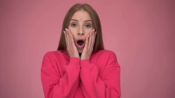 Oh my god, wow. Portrait of stunned shocked woman holding hands on face