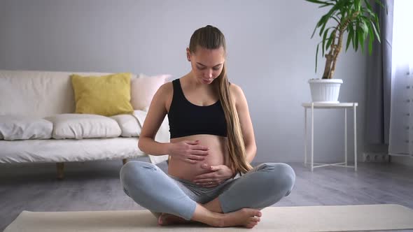 Pregnant Woman Touch Belly in Lotos Position Do Yoga at Home on Mat