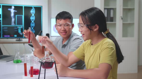 Young Asian Boy And Girl Learning Science Experiment. Study With Scientific Equipment And Test Tubes