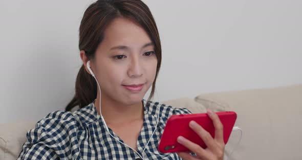 Woman Watch on Phone with Earphone at Home