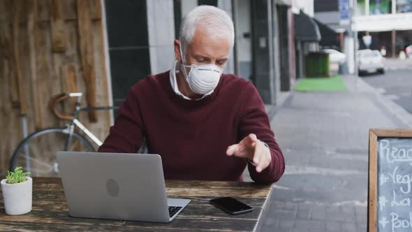 Caucasian man out and about in a coffee wearing a face mask against coronavirus