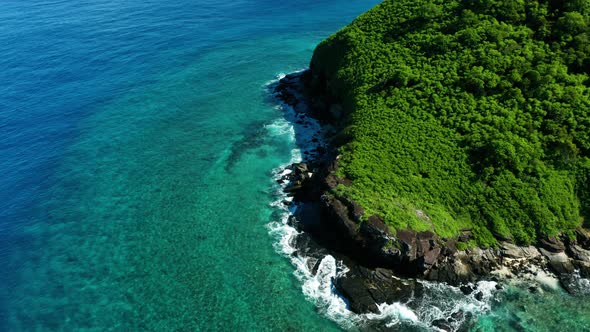 Tropical nature of a Fijian Island surrounded by perfect blue water, aerial shot