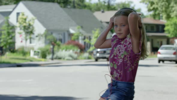 young girl surprised by car crossing street with headphones on