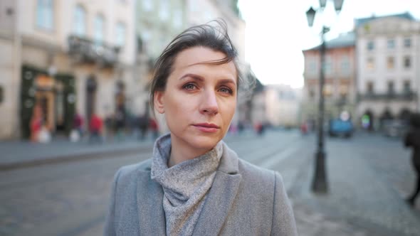 Portrait of a Caucasian Woman in a Coat in the Middle of the Old City Square