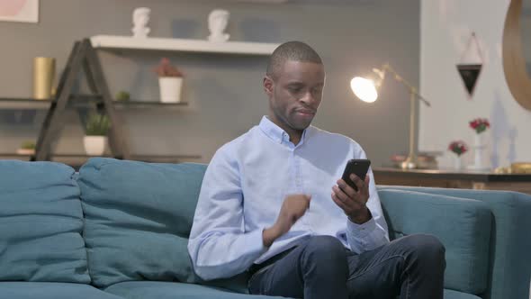 Successful African Man Celebrating on Smartphone